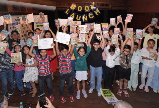 Young authors on stage holding up their books and certificates at a Bukmuk book launch